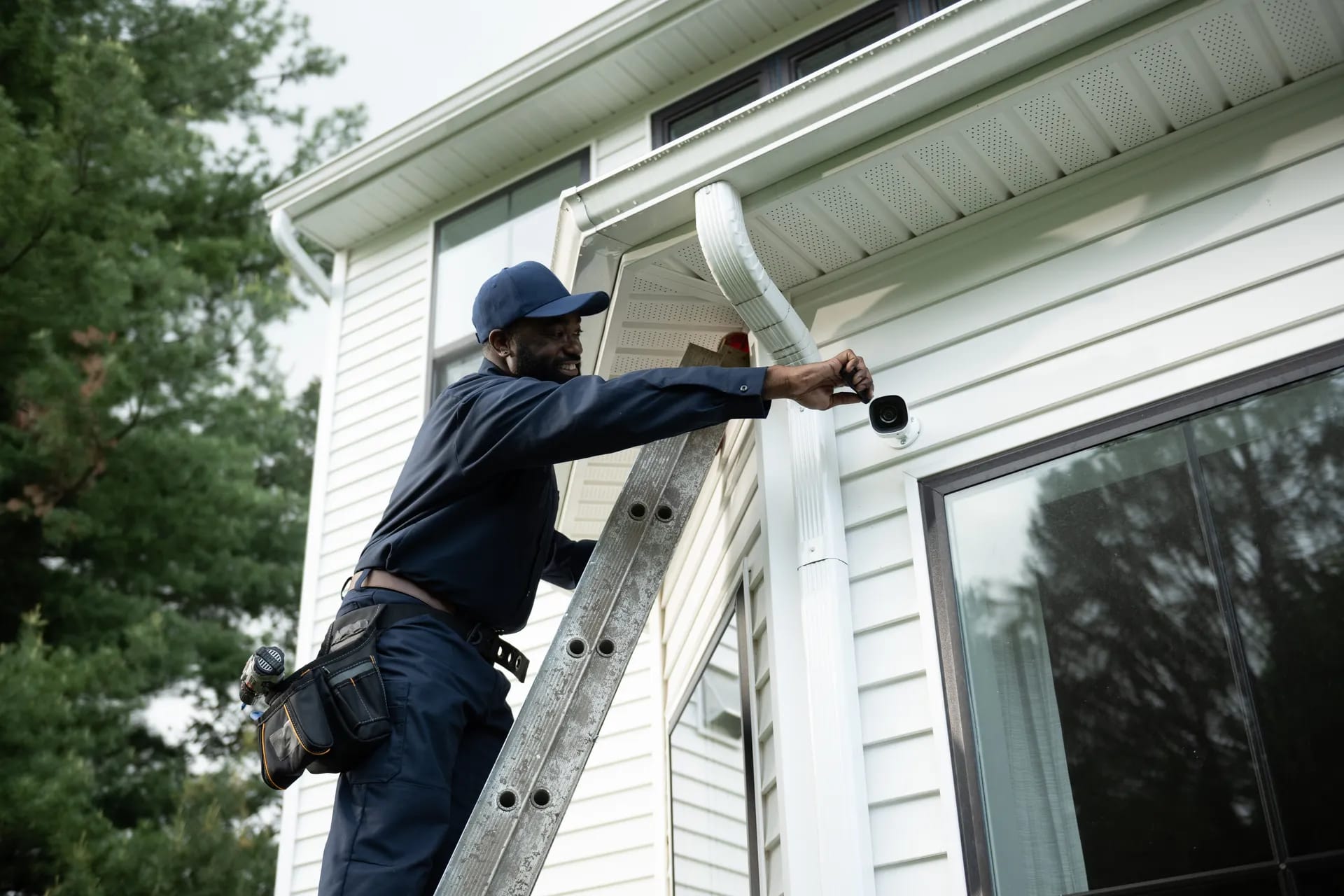Security ONE technician installing a security camera on a home