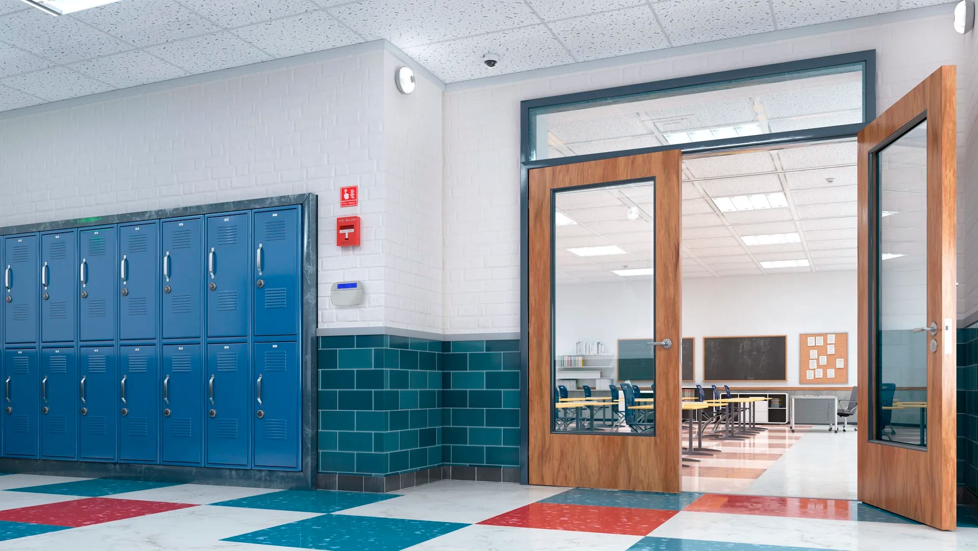 A red fire alarm pull station and security keypad mounted on the wall of a school hallway beside blue lockers and an open classroom door