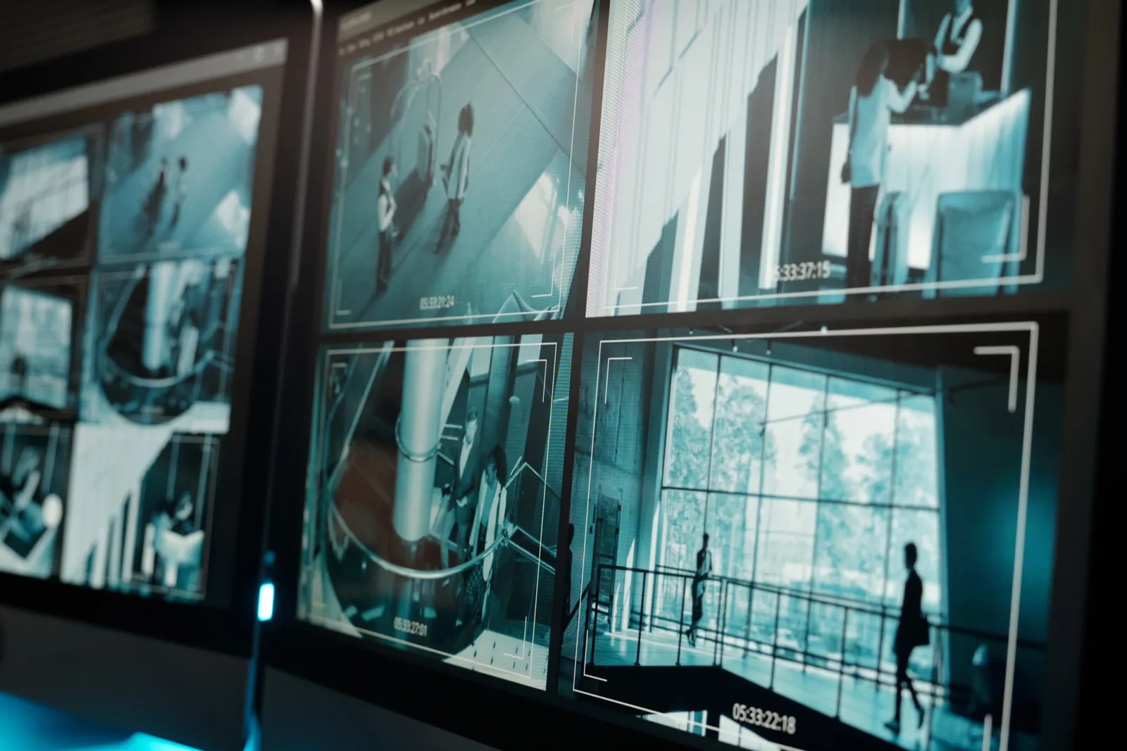 A wall of monitors displaying live security camera footage in a surveillance control room, providing operational oversight across multiple sites