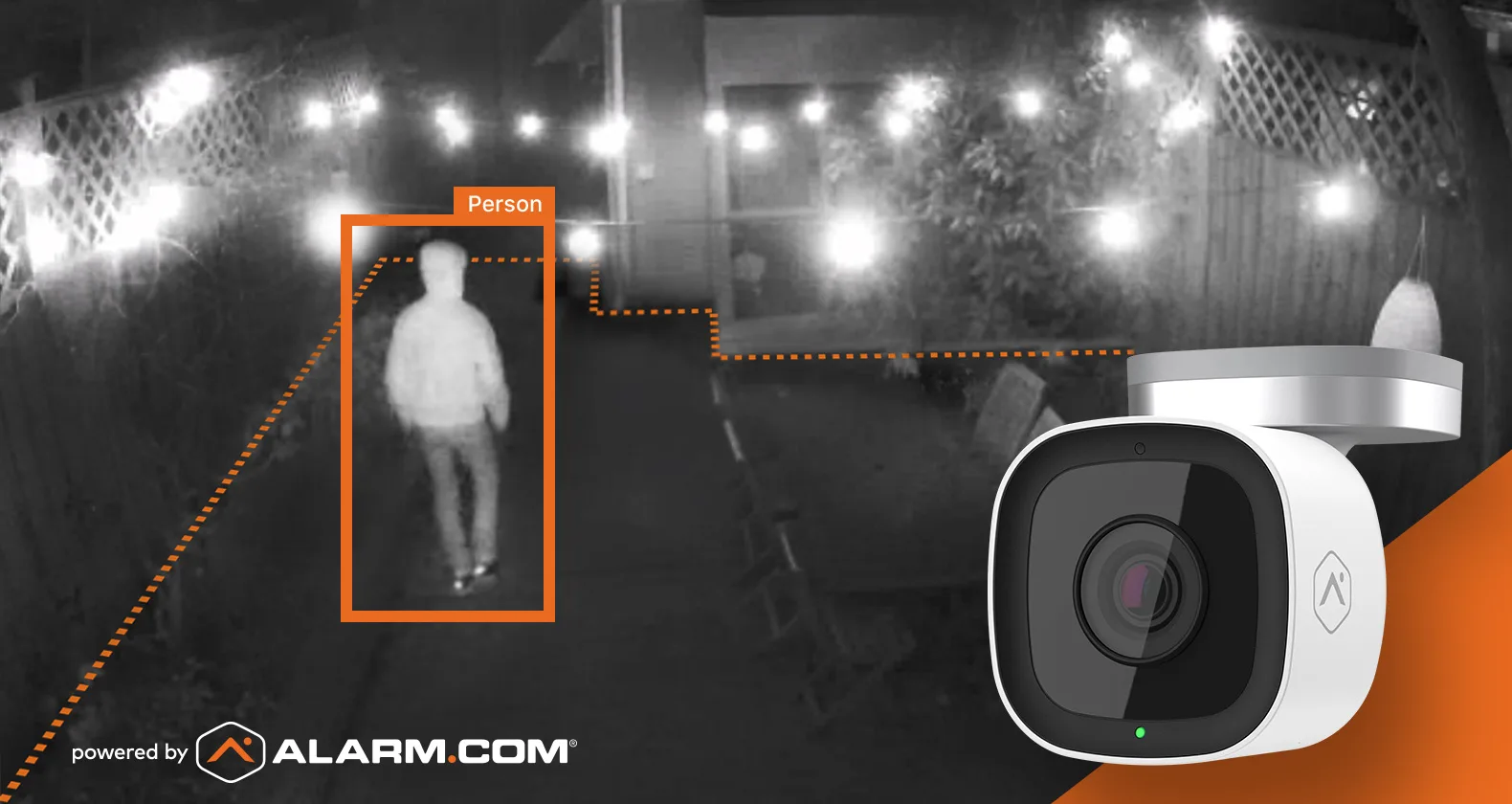 Alarm.com video analytics detecting and boxing a person in a string-lit outdoor scene at night, captured by a wall-mounted bullet security camera