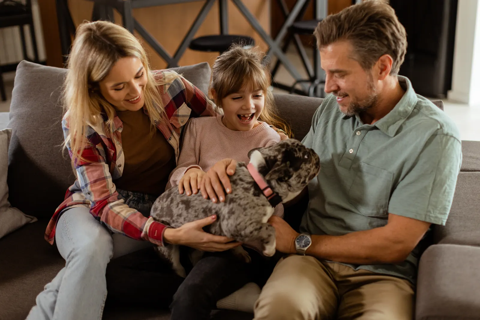 A family relaxing at home with their dog, protected by Security ONE